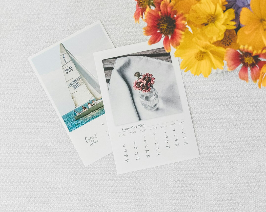 Printed photographs and contact sheets spread on a wooden table